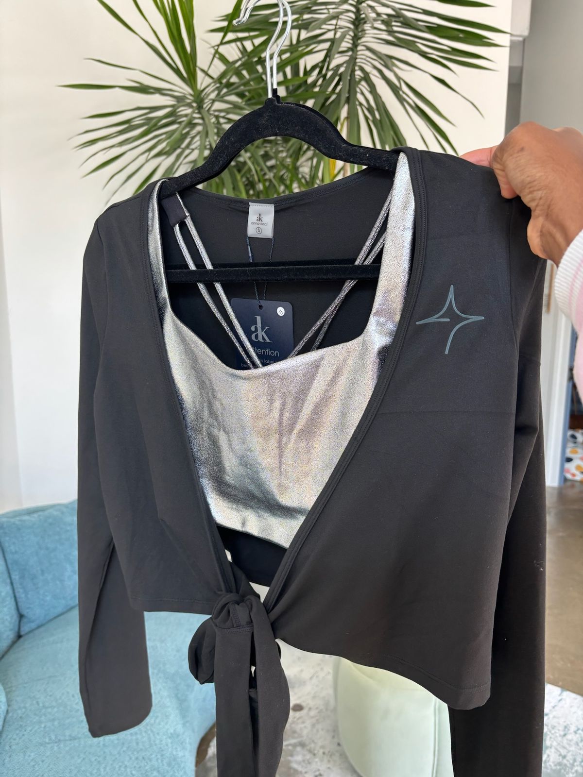 True40 black logo shrug displayed on a hanger with long sleeves, a wrap front and waist tie.
