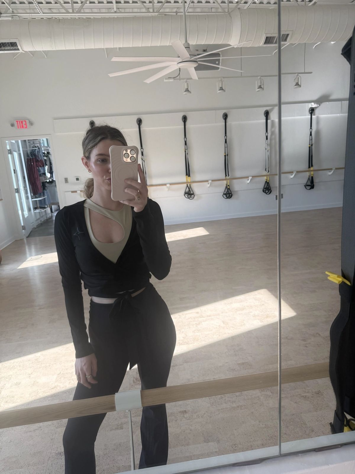 Front view of the True40 black long-sleeve shrug styled with its wrap front tied at the waist.
