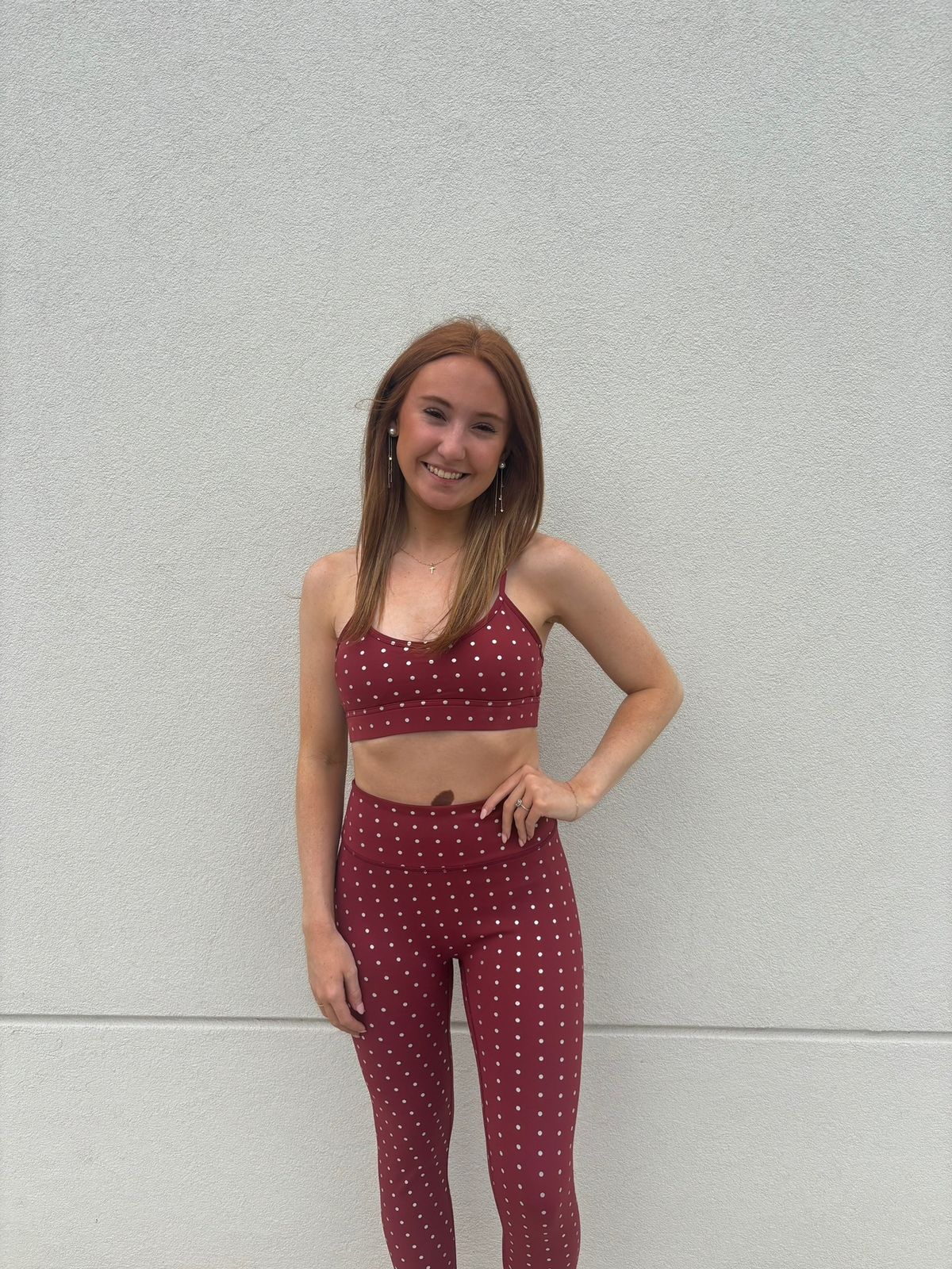 Model wearing the True40 red polka dot sports bra and matching high-waisted leggings.