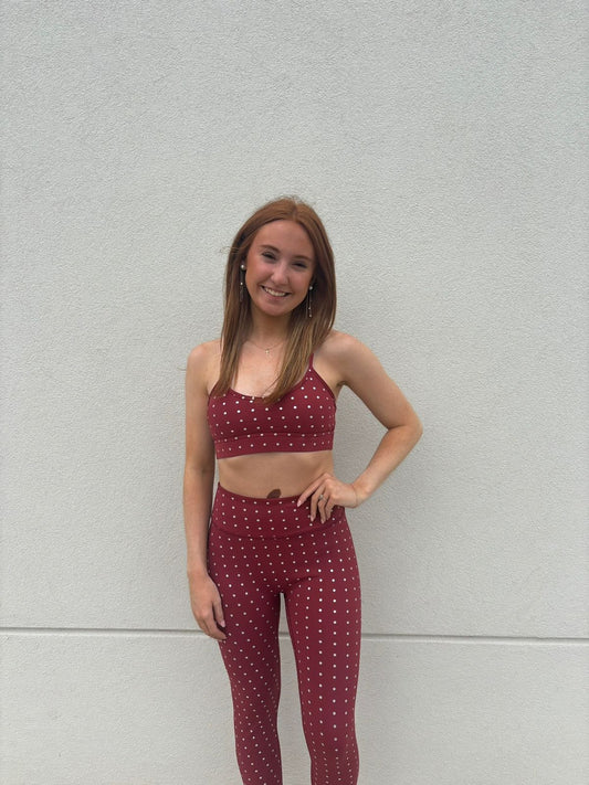 Model wearing the True40 red polka dot sports bra and matching high-waisted leggings.