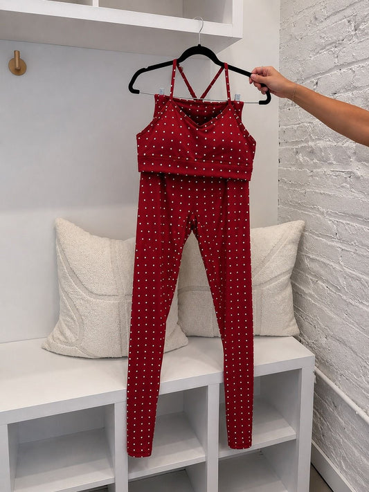 True40 red polka dot sports bra and matching leggings displayed together on a hanger.